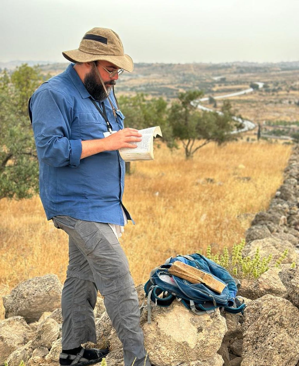 Aaron Shaffier reading the Bible on a hilltop in Israel